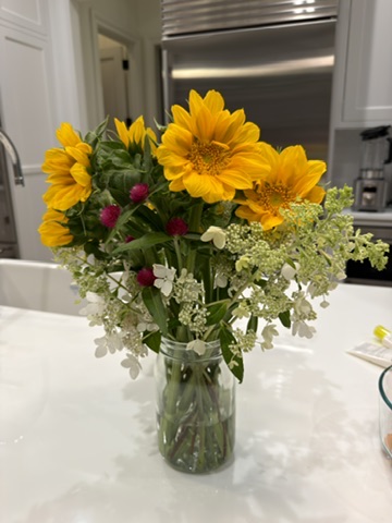Golden flowers and airy white stems in a glass jar