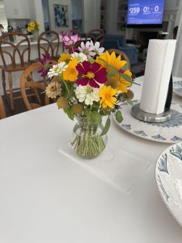 Colorful summer flower arrangement in a clear glass vase on a table